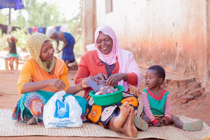 Eine Familie freut sich in Malawi über das Kurban-Paket mit Fleisch.